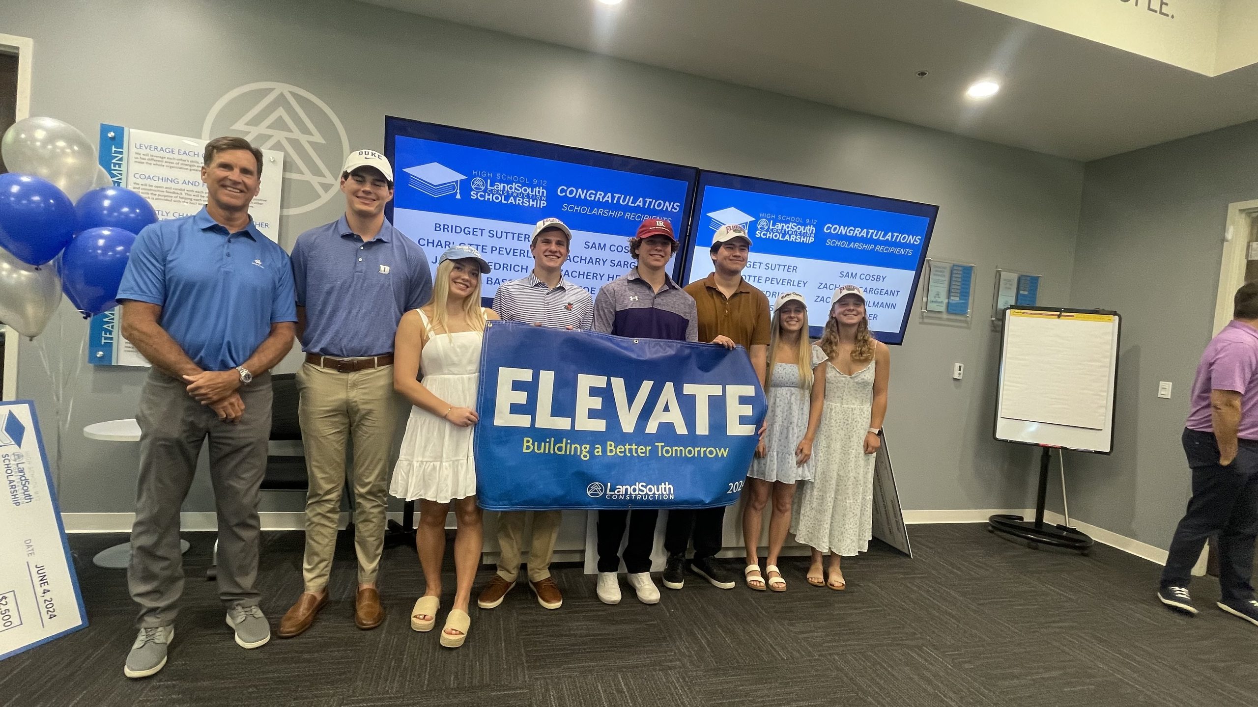 High School 9:12 students and community partners holding an Elevate banner