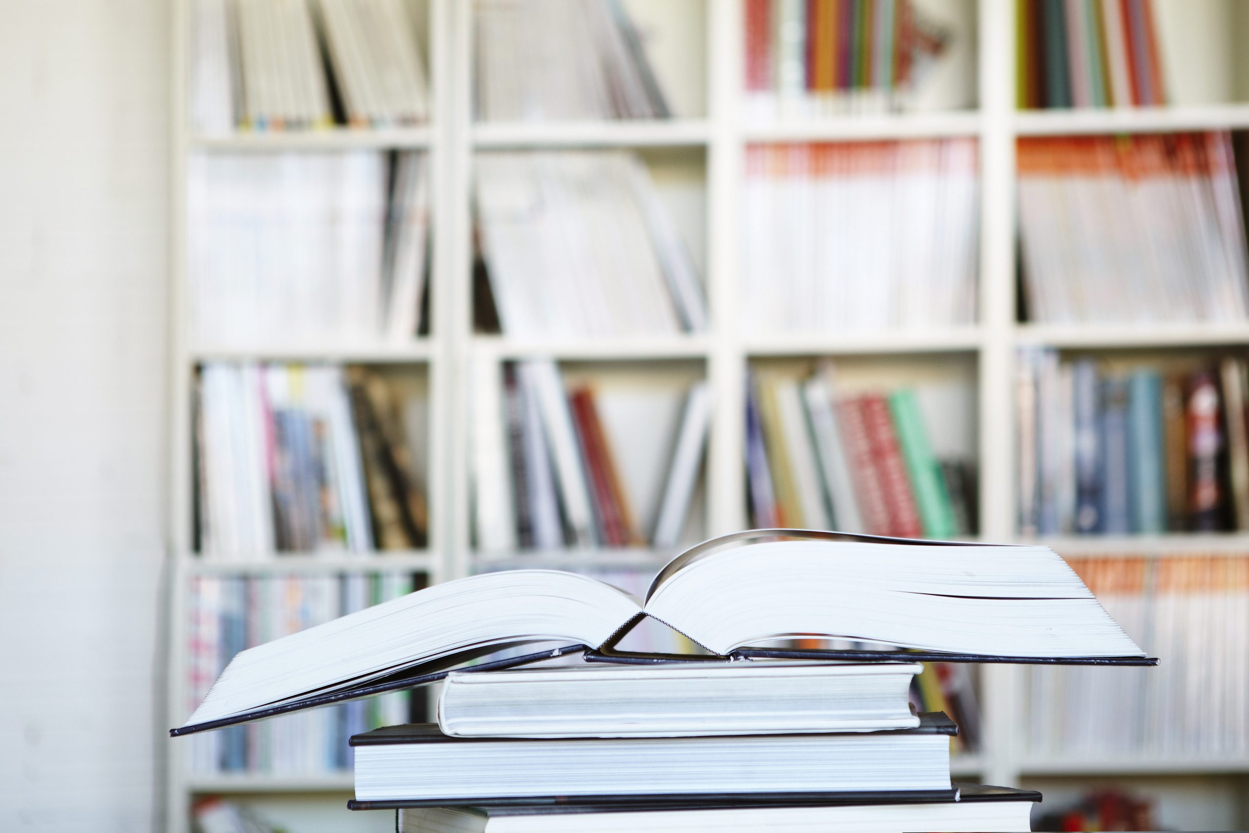 Open book on a stack of books in a library